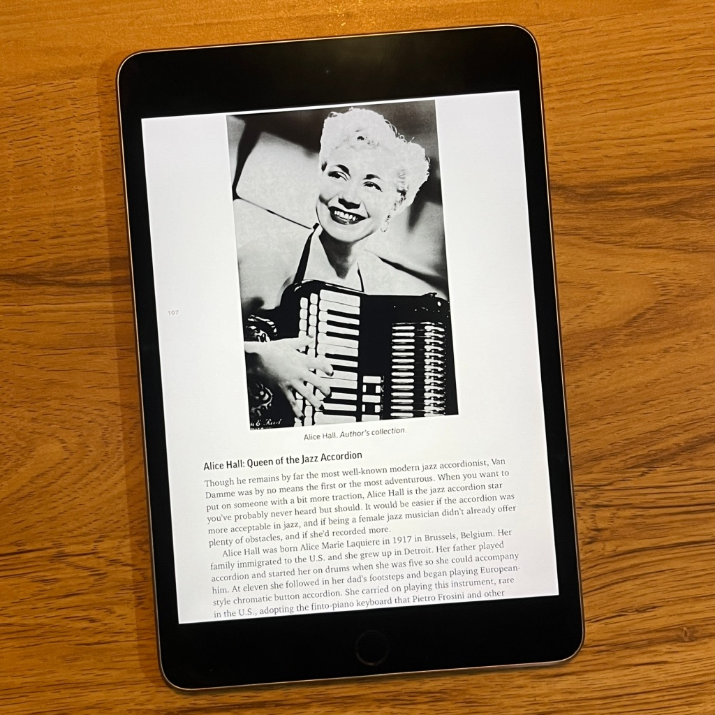 ebook page. Alice Hall, blond smiling white woman in a 1940s glamour shot holding her accordion.